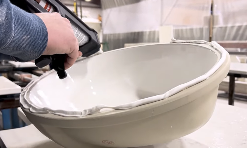 Applying a continuous bead of BoaBond undermount sink adhesive to the rim of a sink bowl